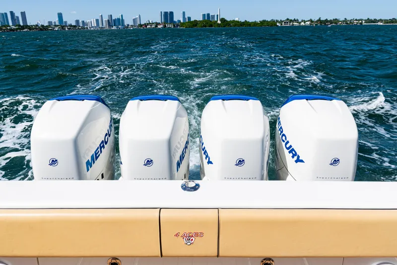 Slide: The Image of 2016 SeaVee 430 boat with four Mercury engines, cruising on open water with city skyline. - 52