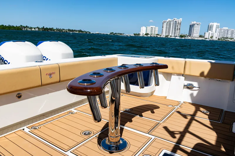 Slide: The Image of 2016 SeaVee 430 boat deck with rod holders, ocean view, and city skyline in background. - 58
