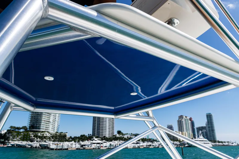 Slide: The Image of 2016 SeaVee 430 boat with blue canopy, city skyline in background. - 74