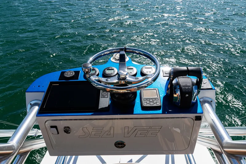 Slide: The Image of Helm of 2016 SeaVee 430 boat with steering wheel and controls, overlooking ocean. - 78