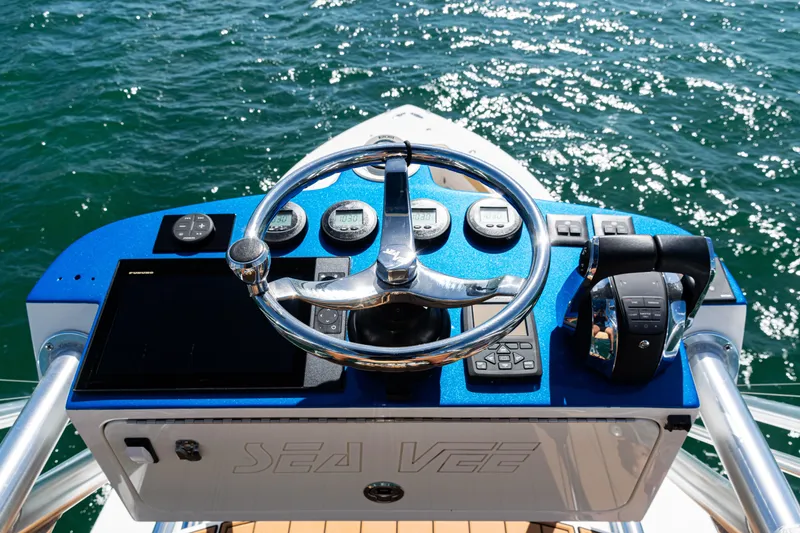Slide: The Image of 2016 SeaVee 430 boat helm with steering wheel and controls on open water. - 79