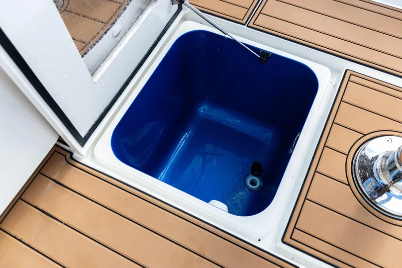 Slide: The Image of Open storage compartment on 2016 SeaVee 430 boat with teak flooring. - 93