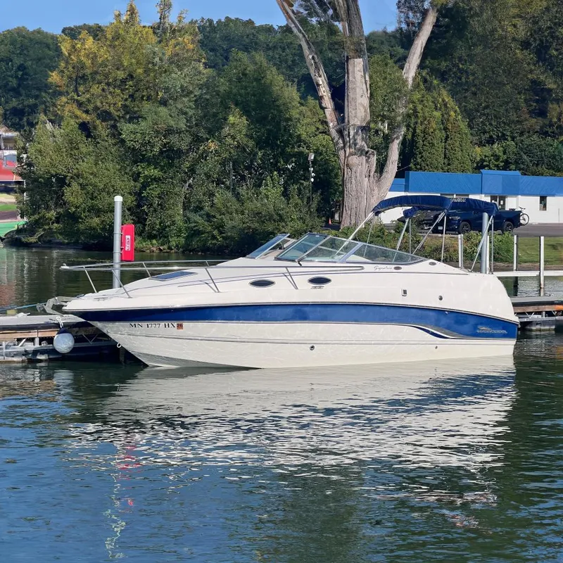 Slide: The Image of Chaparral 196 SSi 1996 boat docked on a calm lake with lush greenery. - 1