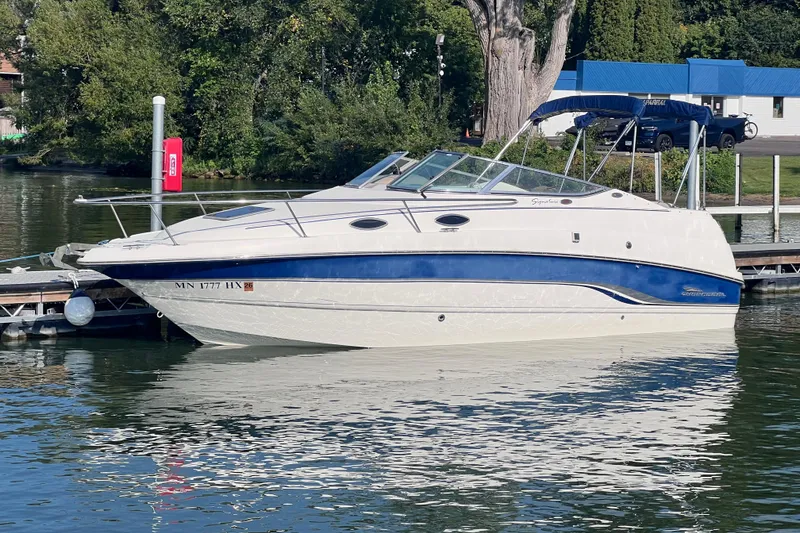 Slide: The Image of Chaparral 196 SSi 1996 boat docked on a calm lake with lush greenery. - 2