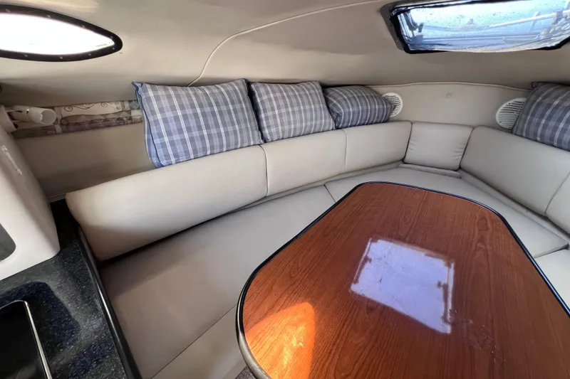 Slide: The Image of Interior of 1996 Chaparral 196 SSi boat with cushioned seating and wooden table. - 27