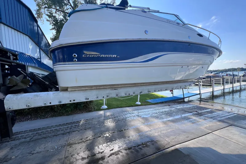 Slide: The Image of 1996 Chaparral 196 SSi boat on lift at marina, blue and white design. - 41