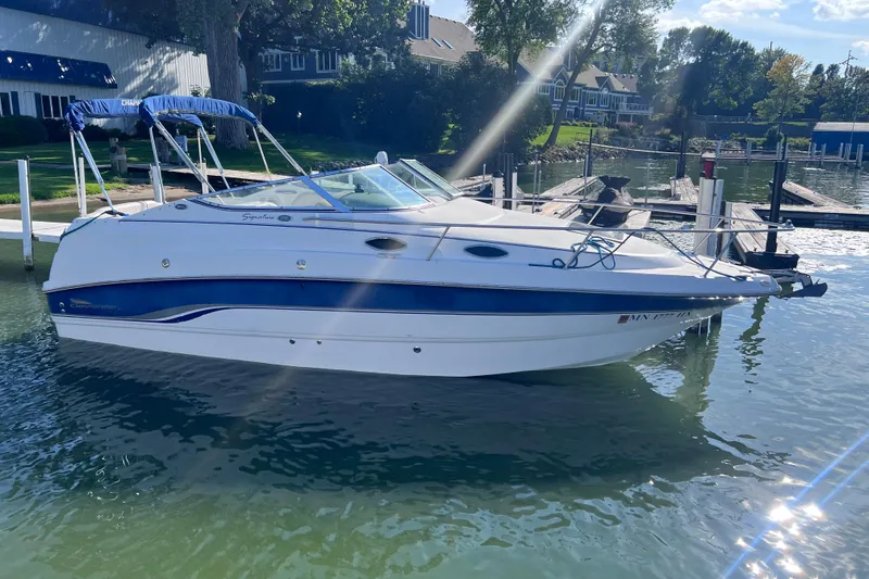 Slide: The Image of 1996 Chaparral 196 SSi boat docked on a sunny day, surrounded by calm water. - 5