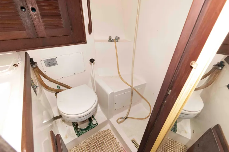 Slide: The Image of 1985 Morgan 384 yacht bathroom with toilet, shower, and wooden accents. - 10