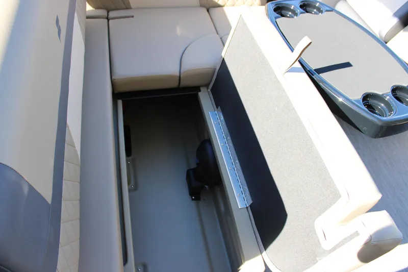 Slide: The Image of 2026 Starcraft EXS 3 Q boat interior with open storage compartment and cup holders. - 14