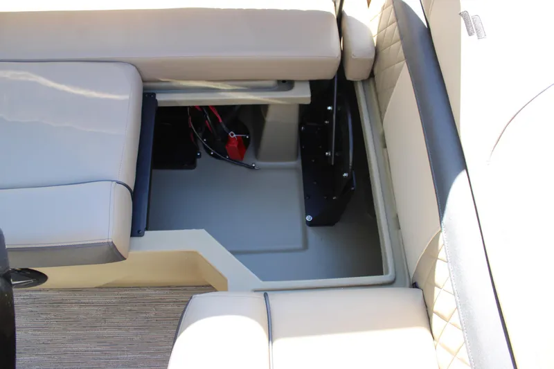 Slide: The Image of 2026 Starcraft EXS 3 Q boat interior storage compartment with beige seating. - 16