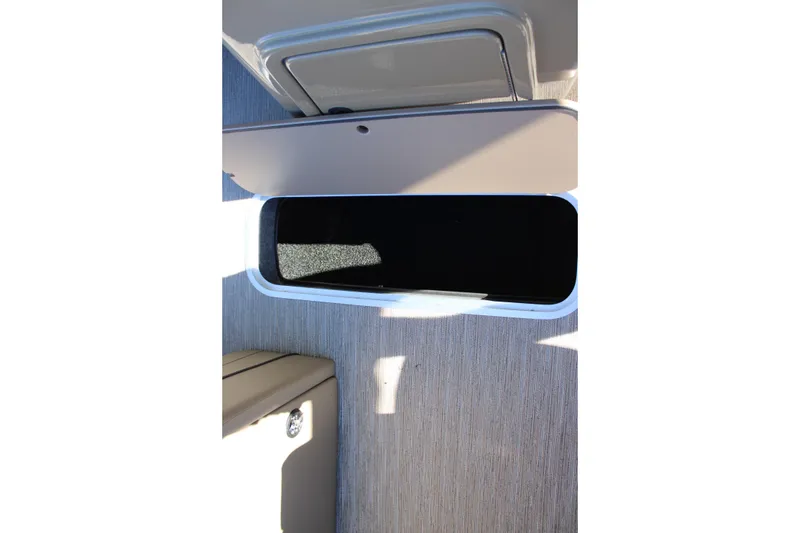 Slide: The Image of Open storage compartment on 2026 Starcraft EXS 3 Q boat, featuring beige interior. - 23