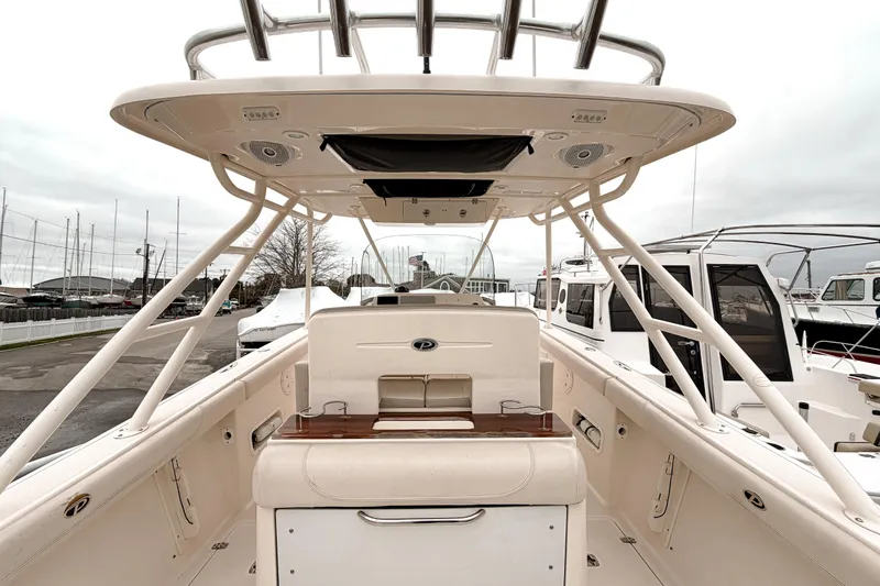 Slide: The Image of 2014 Pursuit S 280 Sport boat interior, featuring helm and seating area at a marina. - 10