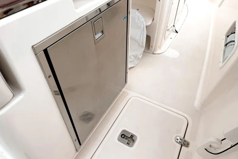 Slide: The Image of 2014 Pursuit S 280 Sport boat interior with stainless steel door and storage compartments. - 12