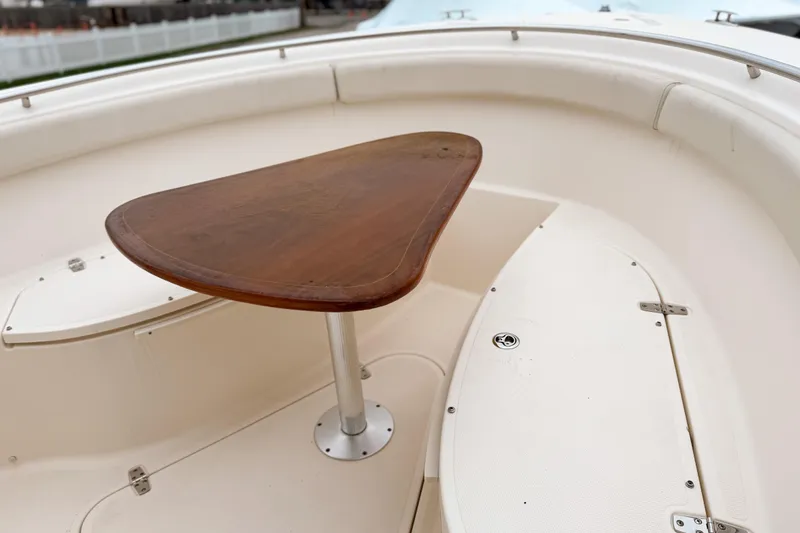 Slide: The Image of 2014 Pursuit S 280 Sport boat interior with wooden table and white seating. - 21