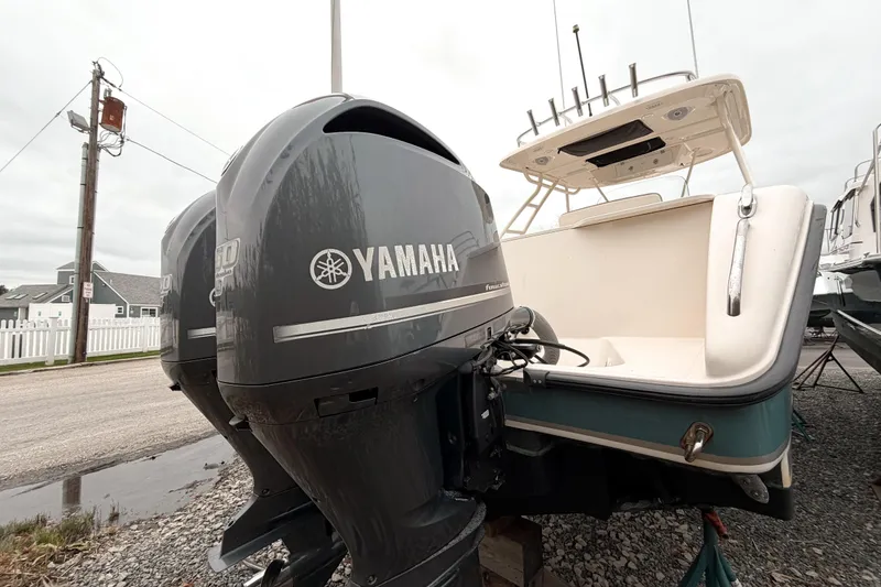 Slide: The Image of 2014 Pursuit S 280 Sport boat with Yamaha outboard engines, parked on gravel. - 3