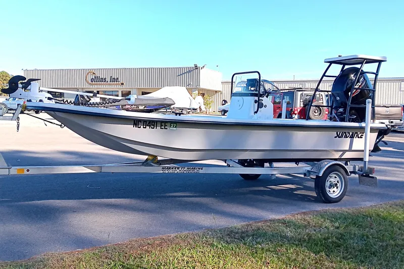 Slide: The Image of 2014 Sundance K16CC boat on trailer in parking lot, side view. - 1