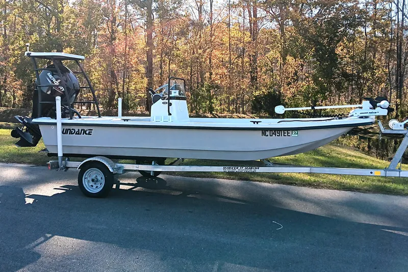 Slide: The Image of 2014 Sundance K16CC boat on trailer, parked on road with autumn trees in background. - 3