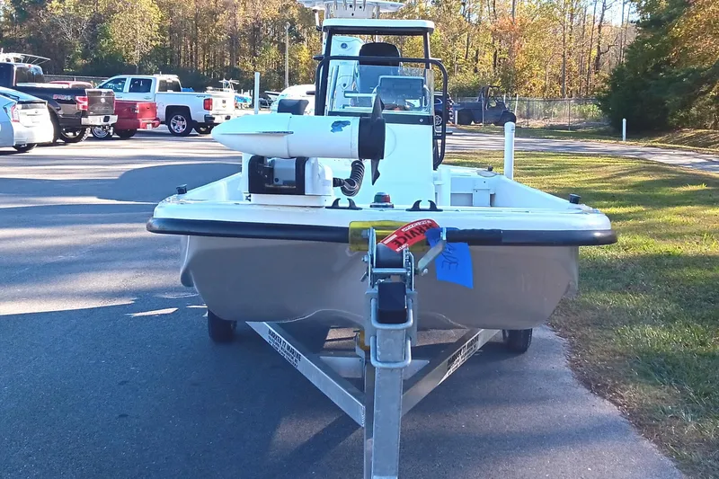 Slide: The Image of 2014 Sundance K16CC boat on trailer in parking lot, surrounded by trees and vehicles. - 6
