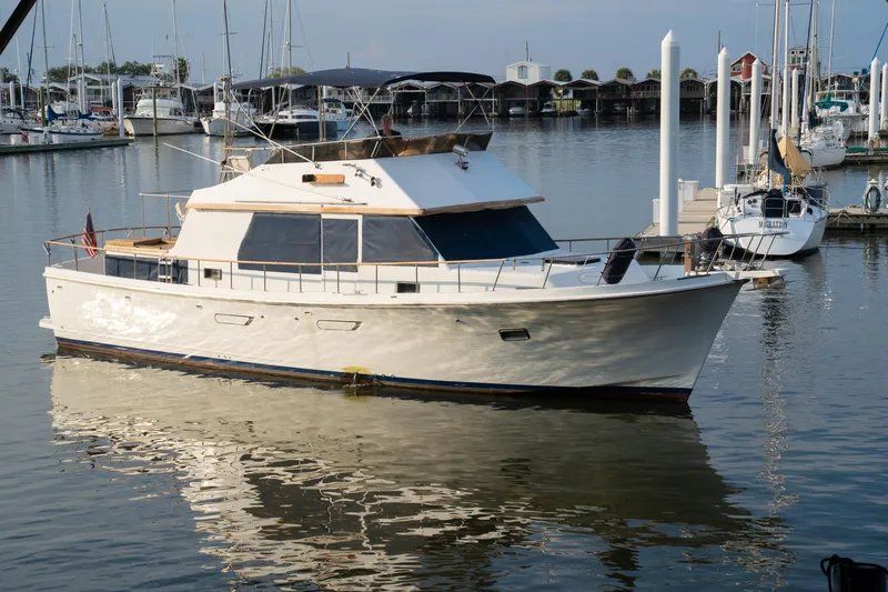 The Image of 1991 Marine Trader 46 fast trawler docked in a marina, reflecting on calm water. - 1