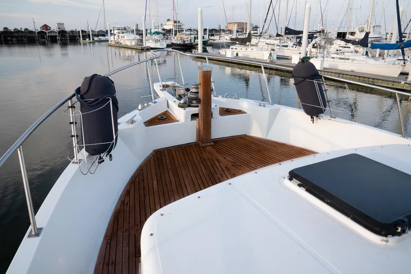 Slide: The Image of 1991 Marine Trader 46 fast trawler docked at marina, featuring spacious deck and elegant design. - 12