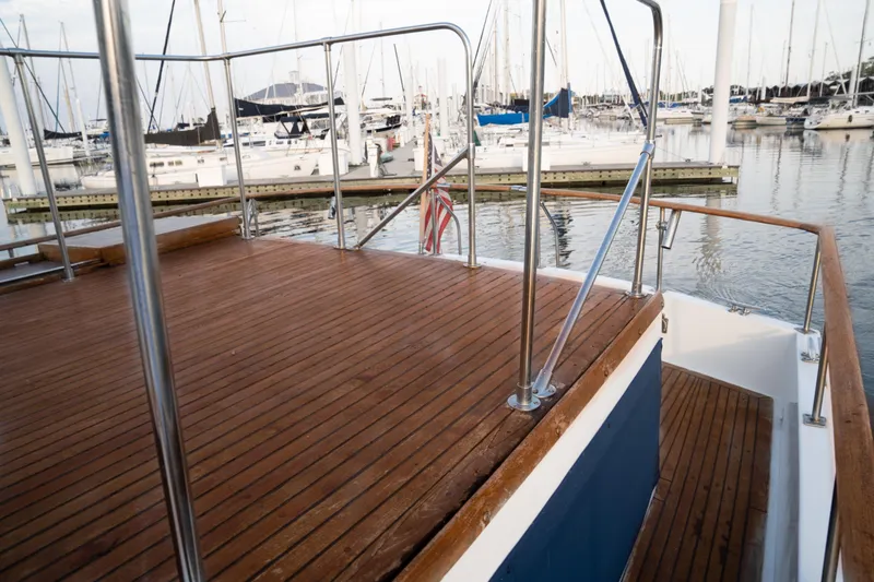 Slide: The Image of Deck of 1991 Marine Trader 46 fast trawler in marina, showcasing wooden flooring and railing. - 13
