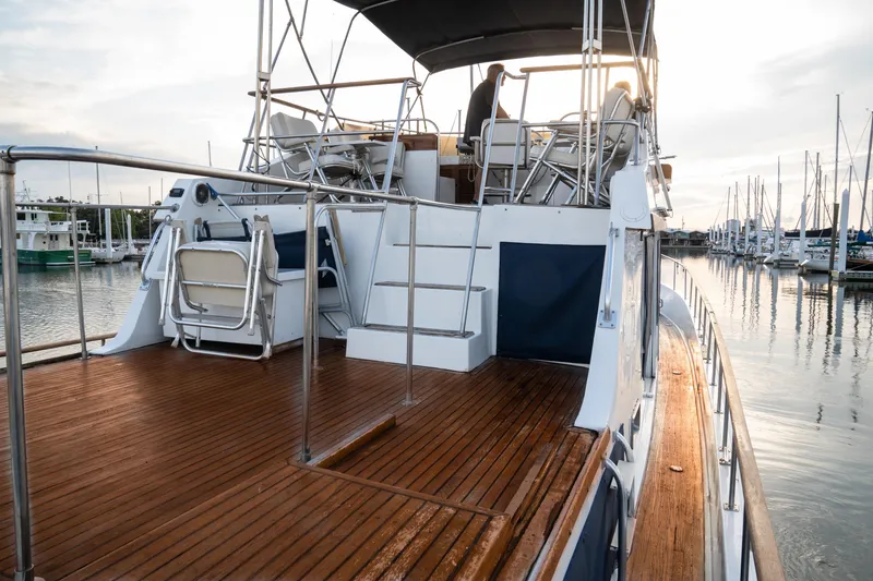 Slide: The Image of 1991 Marine Trader 46 fast trawler with wooden deck, docked at marina during sunset. - 14