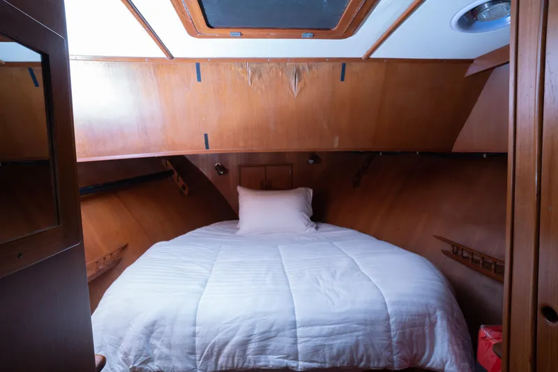 Slide: The Image of Cozy cabin bedroom in 1991 Marine Trader 46 fast trawler with wood paneling and skylight. - 25