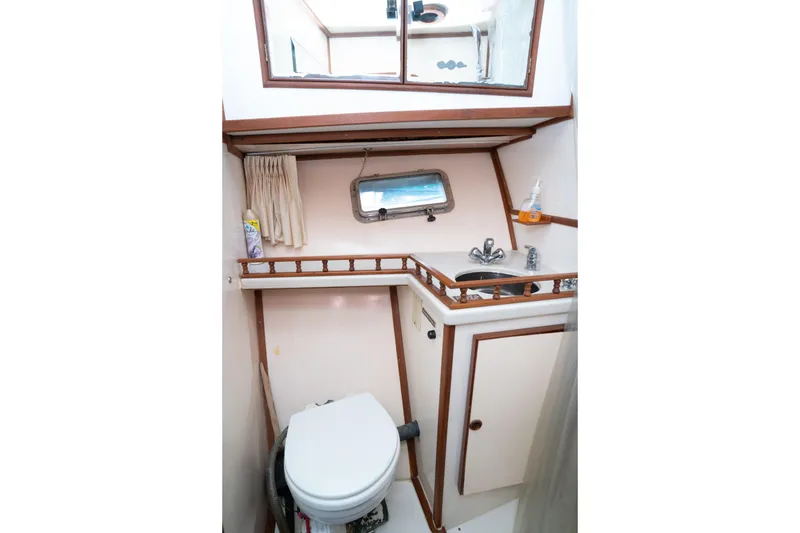 Slide: The Image of Marine Trader 46 fast trawler 1991 bathroom with sink, toilet, and porthole window. - 26