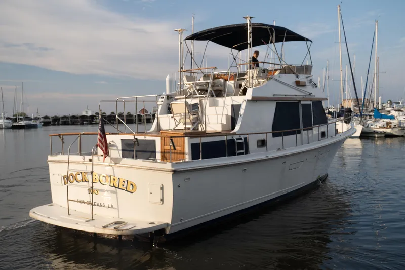 Slide: The Image of 1991 Marine Trader 46 fast trawler docked in a marina, featuring a spacious deck. - 8