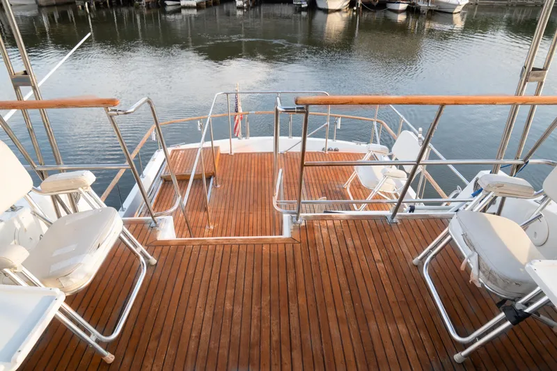 Slide: The Image of 1991 Marine Trader 46 fast trawler deck with wooden flooring and seating, docked at marina. - 9