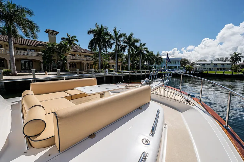 Slide: The Image of Luxurious 2013 Grand Banks 54 Europa yacht with elegant deck seating, docked by palm trees. - 18