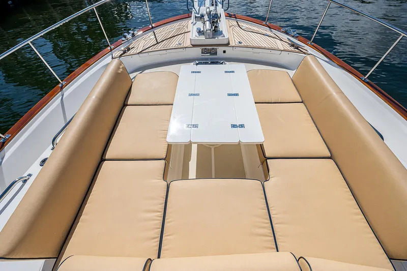 Slide: The Image of Luxurious seating area on 2013 Grand Banks 54 Europa yacht, featuring tan cushions and a central table. - 19