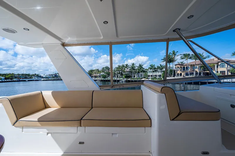 Slide: The Image of Luxurious seating area on 2013 Grand Banks 54 Europa yacht, overlooking waterfront homes and palm trees. - 37
