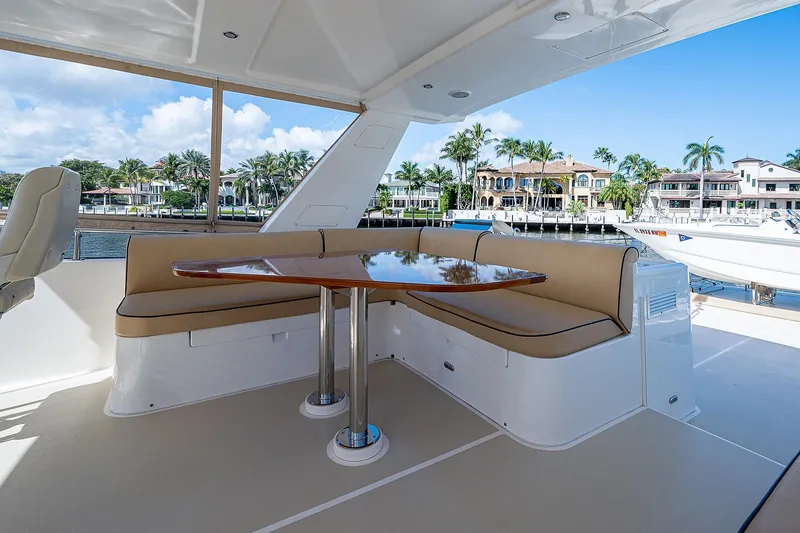 Slide: The Image of Outdoor seating area on a 2013 Grand Banks 54 Europa yacht, featuring a wooden table. - 39
