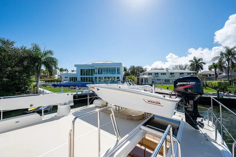 Slide: The Image of Grand Banks 54 Europa yacht docked near luxury waterfront homes, sunny day. - 42
