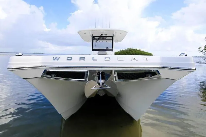 Slide: The Image of 2026 World Cat 280 CC-X boat cruising on a calm river with lush greenery. - 2