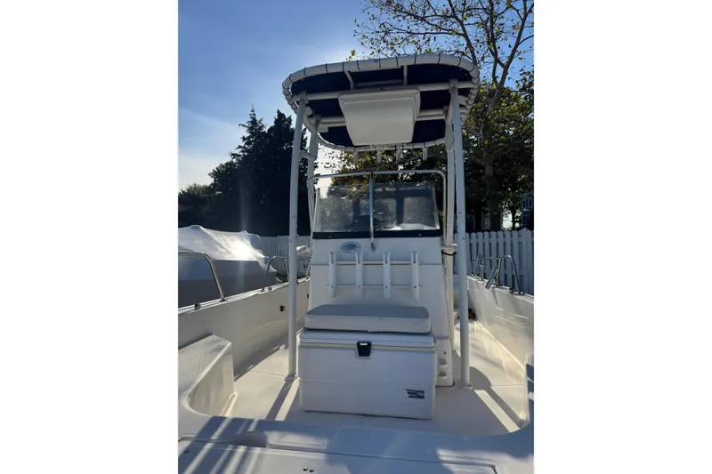Slide: The Image of 2015 Boston Whaler 190 Montauk boat with T-top and seating, docked outdoors. - 4