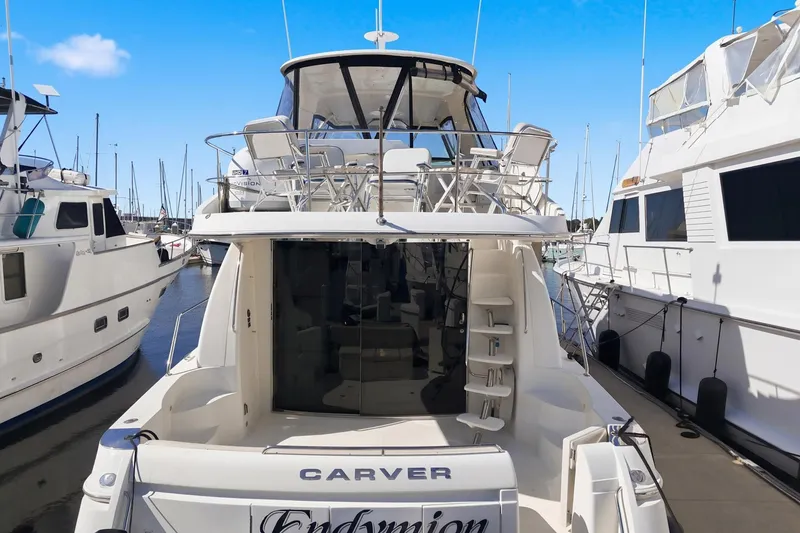 Slide: The Image of 2006 Carver 56 Voyager yacht docked at marina, rear view with clear blue sky. - 13