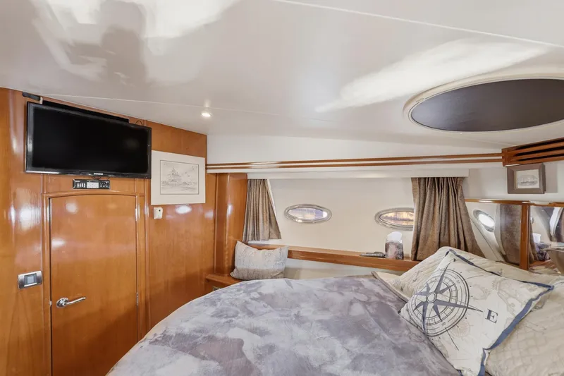 Slide: The Image of Luxurious 2006 Carver 56 Voyager yacht bedroom with TV and nautical decor. - 29