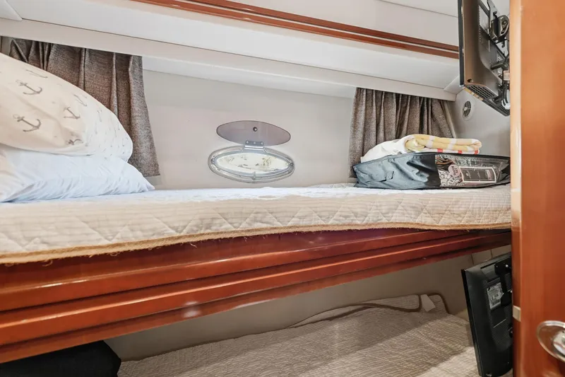 Slide: The Image of 2006 Carver 56 Voyager cabin with cozy bunk bed, porthole, and nautical-themed decor. - 32