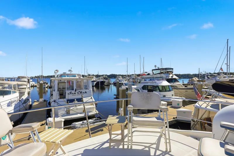 Slide: The Image of Marina view with 2006 Carver 56 Voyager yacht among docked boats under clear blue sky. - 48