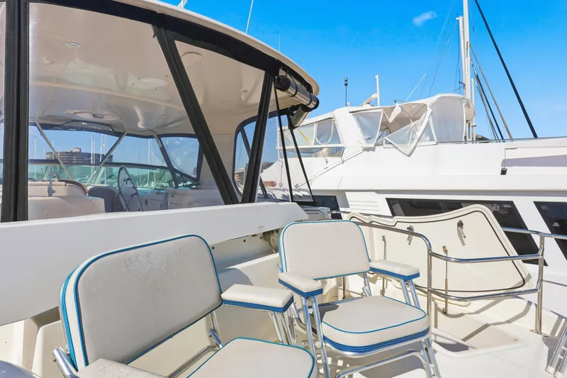Slide: The Image of 2006 Carver 56 Voyager yacht deck with seating, docked under clear blue sky. - 49