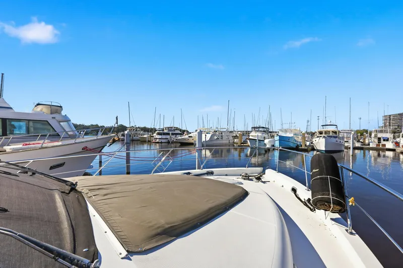 Slide: The Image of 2006 Carver 56 Voyager yacht docked at a marina under clear blue skies. - 50