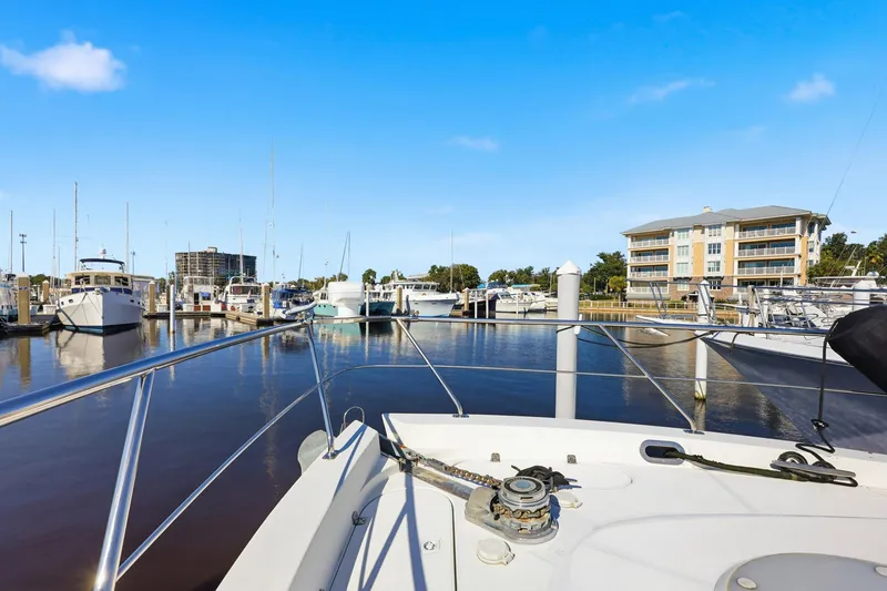 Slide: The Image of 2006 Carver 56 Voyager yacht docked at a marina with clear blue skies. - 52