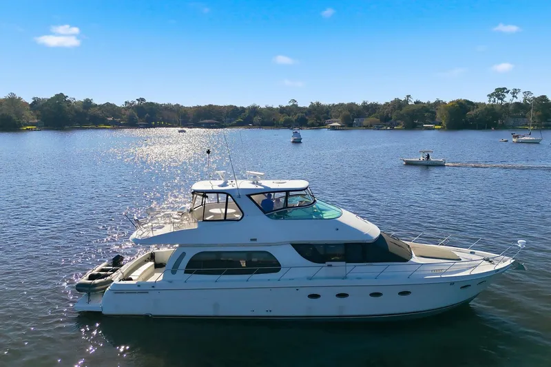 Slide: The Image of 2006 Carver 56 Voyager yacht cruising on a sunny lake with other boats nearby. - 8