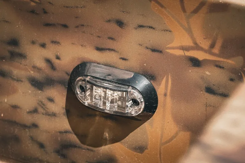 Slide: The Image of Close-up of a 2026 G3 Gator Tough 18 CCJ boat light on camo-patterned surface. - 14