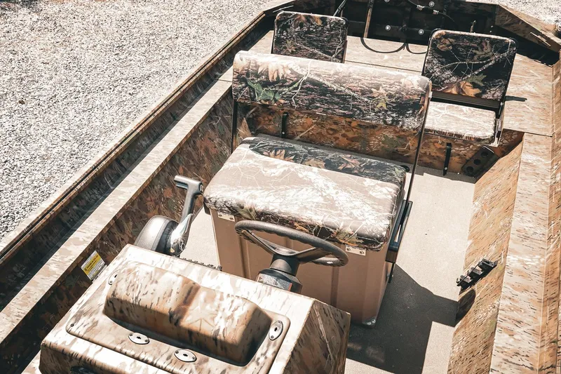 Slide: The Image of 2026 G3 Gator Tough 18 CCJ boat interior with camo seating and steering console. - 19