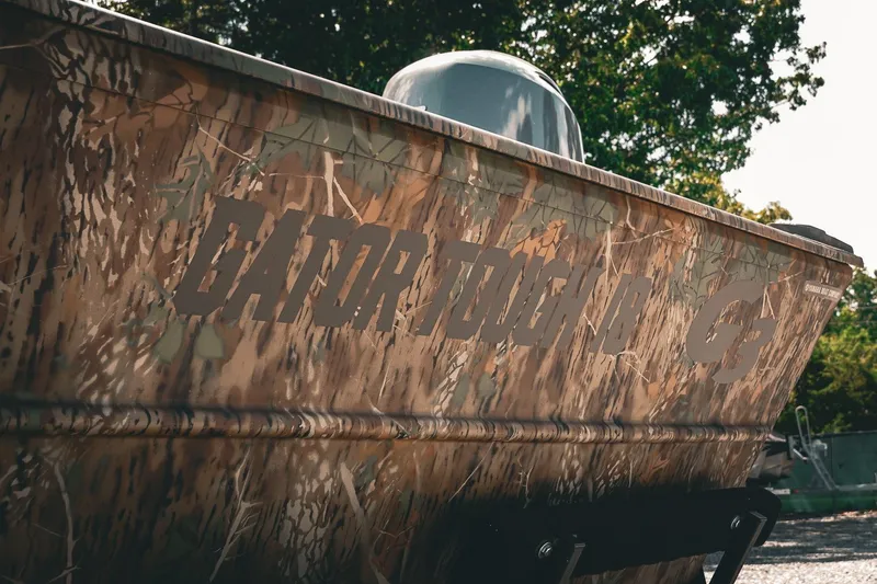 Slide: The Image of 2026 G3 Gator Tough 18 CCJ boat with camouflage design, outdoors. - 29