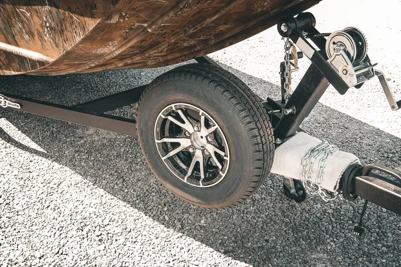 Slide: The Image of Trailer wheel and hitch of 2026 G3 Gator Tough 18 CCJ boat on gravel. - 31