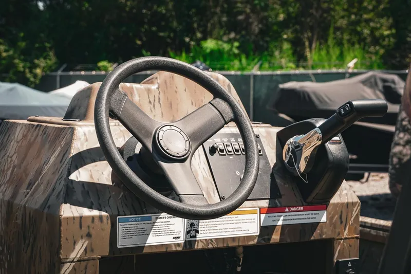 Slide: The Image of 2026 G3 Gator Tough 18 CCJ boat console with steering wheel and controls. - 9